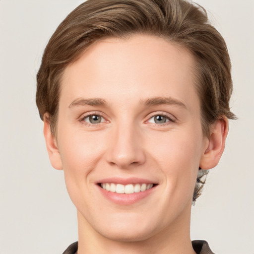 Joyful white young-adult female with short  brown hair and grey eyes