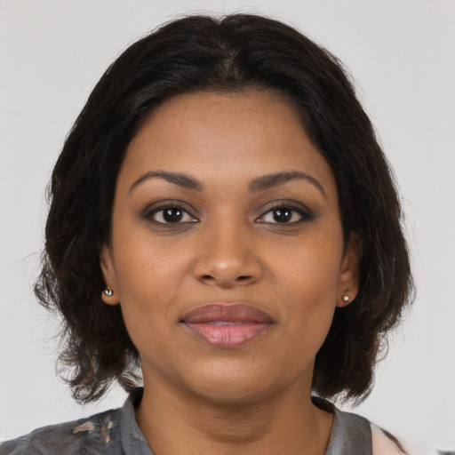 Joyful black young-adult female with medium  brown hair and brown eyes