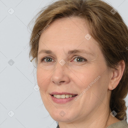 Joyful white adult female with medium  brown hair and grey eyes