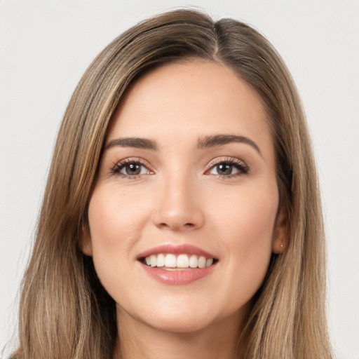 Joyful white young-adult female with long  brown hair and brown eyes