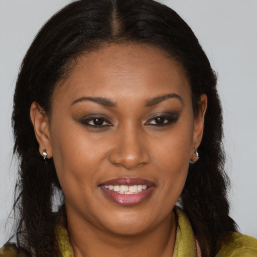 Joyful black young-adult female with long  brown hair and brown eyes