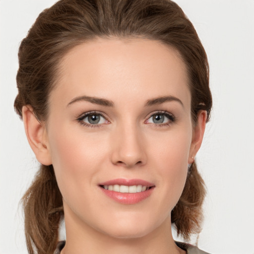 Joyful white young-adult female with medium  brown hair and grey eyes