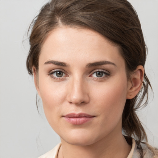 Joyful white young-adult female with medium  brown hair and grey eyes