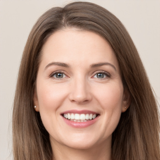 Joyful white young-adult female with long  brown hair and grey eyes