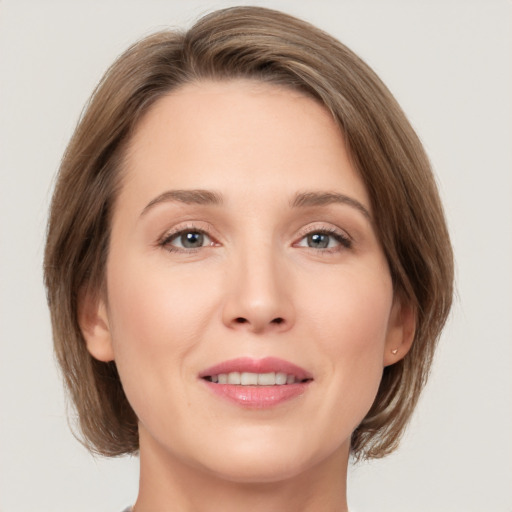 Joyful white young-adult female with medium  brown hair and green eyes