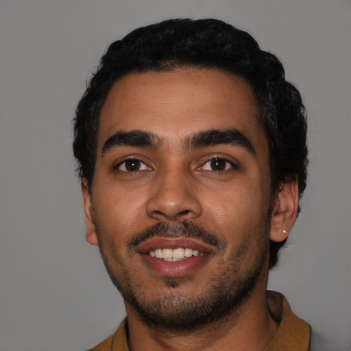 Joyful latino young-adult male with short  black hair and brown eyes