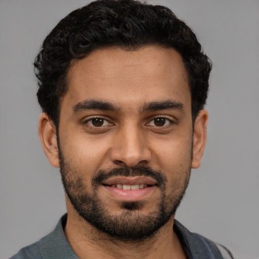 Joyful latino young-adult male with short  black hair and brown eyes