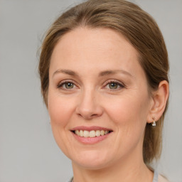 Joyful white adult female with medium  brown hair and green eyes