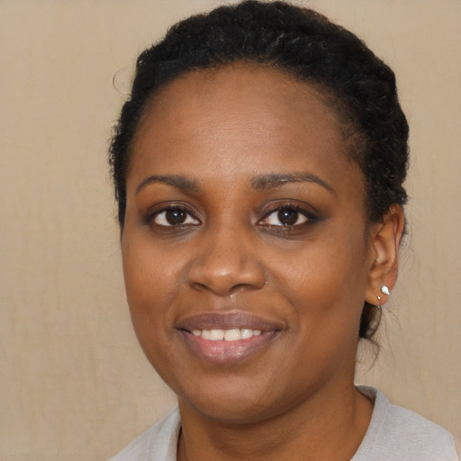 Joyful black young-adult female with short  brown hair and brown eyes