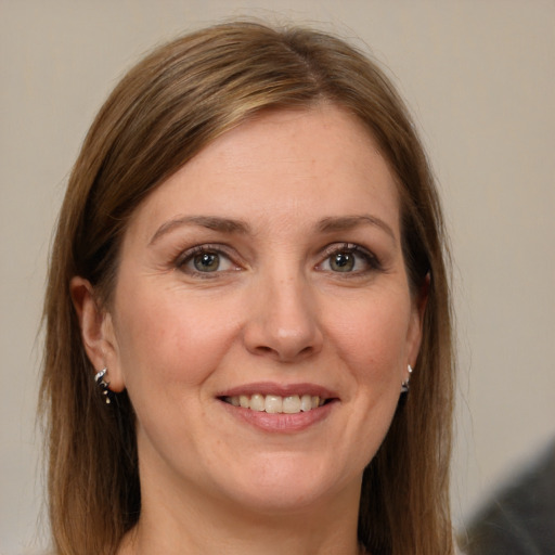 Joyful white adult female with long  brown hair and grey eyes