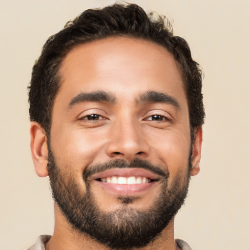 Joyful latino young-adult male with short  brown hair and brown eyes