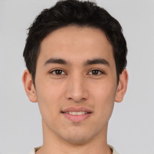 Joyful latino young-adult male with short  brown hair and brown eyes