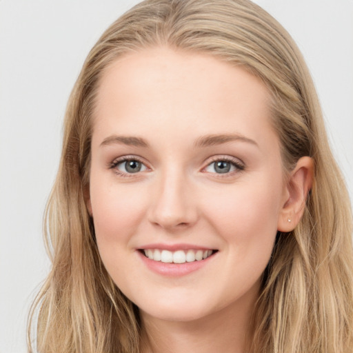 Joyful white young-adult female with long  brown hair and blue eyes