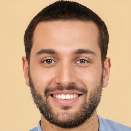 Joyful white young-adult male with short  black hair and brown eyes