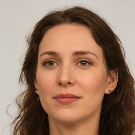 Joyful white adult female with long  brown hair and green eyes