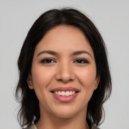 Joyful latino young-adult female with medium  brown hair and brown eyes