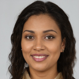 Joyful black young-adult female with long  brown hair and brown eyes