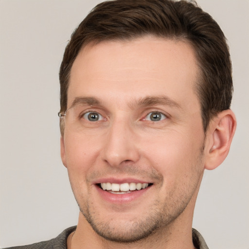 Joyful white young-adult male with short  brown hair and grey eyes