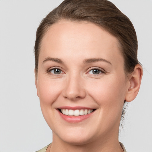 Joyful white young-adult female with short  brown hair and grey eyes