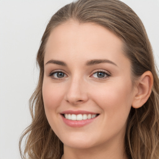 Joyful white young-adult female with long  brown hair and grey eyes