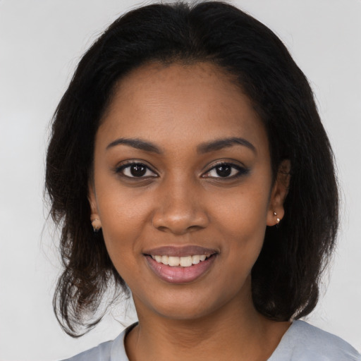 Joyful black young-adult female with medium  brown hair and brown eyes