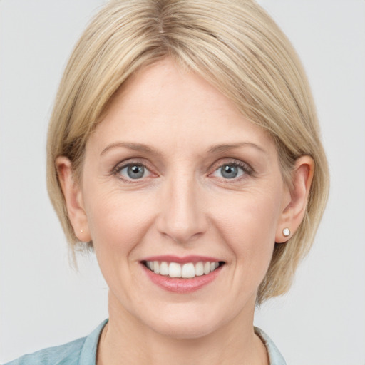 Joyful white adult female with medium  brown hair and blue eyes