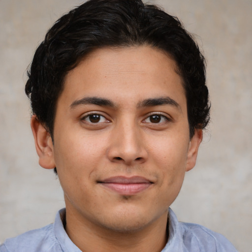 Joyful latino young-adult male with short  brown hair and brown eyes