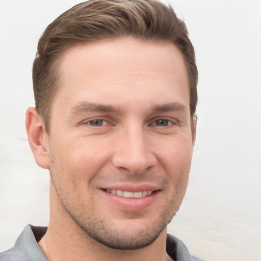 Joyful white young-adult male with short  brown hair and grey eyes