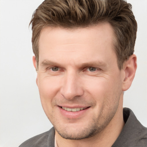 Joyful white adult male with short  brown hair and grey eyes