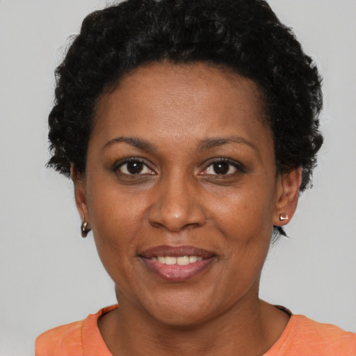 Joyful black adult female with short  brown hair and brown eyes