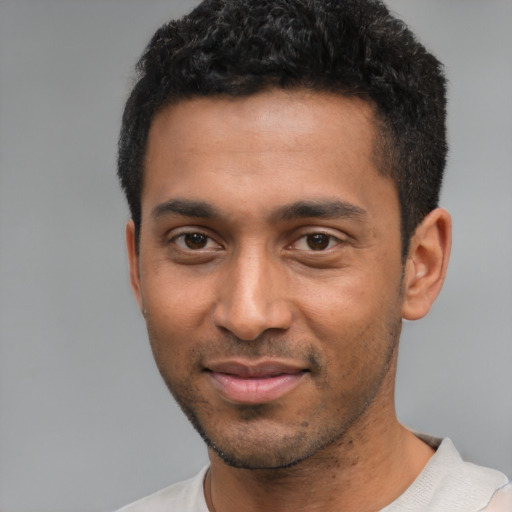 Joyful black young-adult male with short  black hair and brown eyes