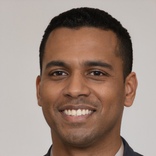 Joyful black young-adult male with short  black hair and brown eyes