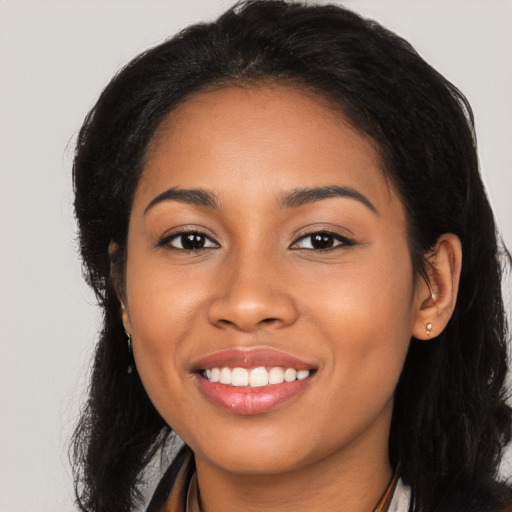 Joyful latino young-adult female with long  black hair and brown eyes