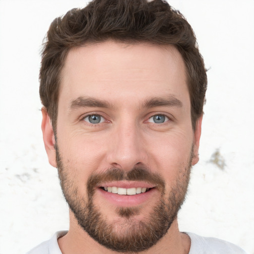 Joyful white young-adult male with short  brown hair and grey eyes