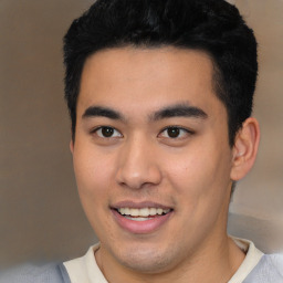 Joyful latino young-adult male with short  brown hair and brown eyes