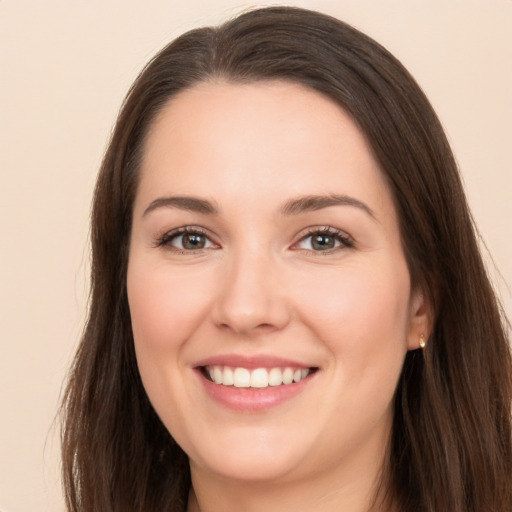 Joyful white young-adult female with long  brown hair and brown eyes