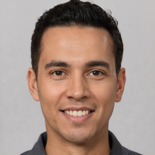 Joyful white young-adult male with short  black hair and brown eyes