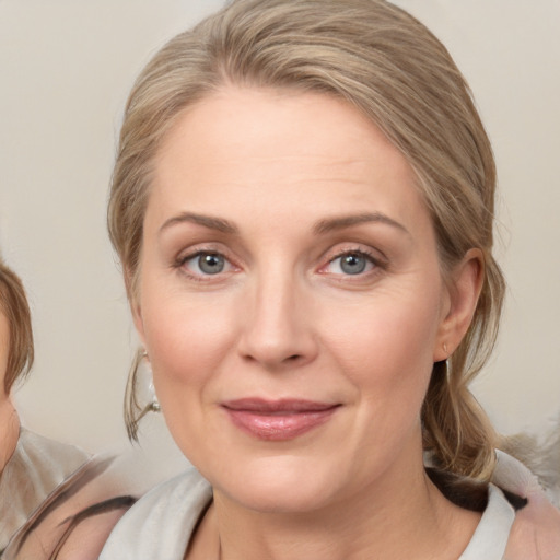 Joyful white adult female with medium  brown hair and blue eyes