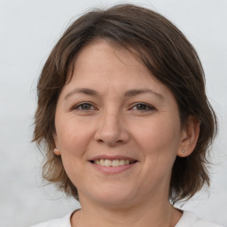 Joyful white adult female with medium  brown hair and brown eyes