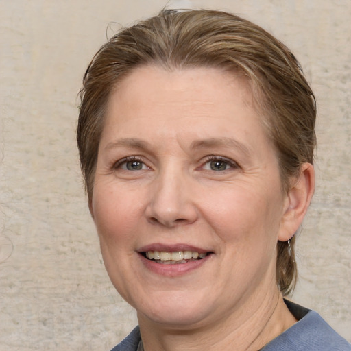 Joyful white adult female with medium  brown hair and blue eyes