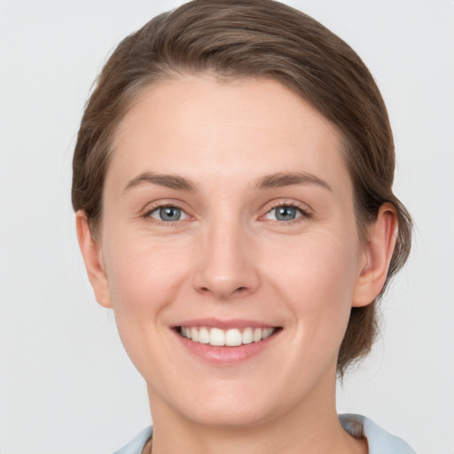 Joyful white young-adult female with short  brown hair and grey eyes