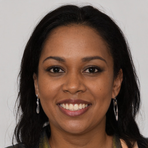 Joyful black young-adult female with long  brown hair and brown eyes