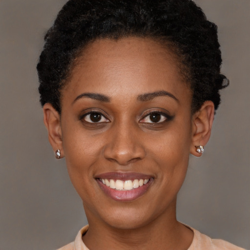Joyful black young-adult female with short  brown hair and brown eyes