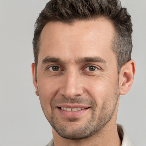 Joyful white adult male with short  brown hair and brown eyes