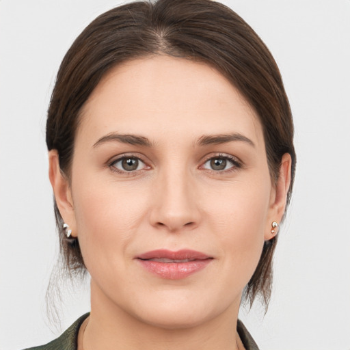 Joyful white young-adult female with medium  brown hair and grey eyes