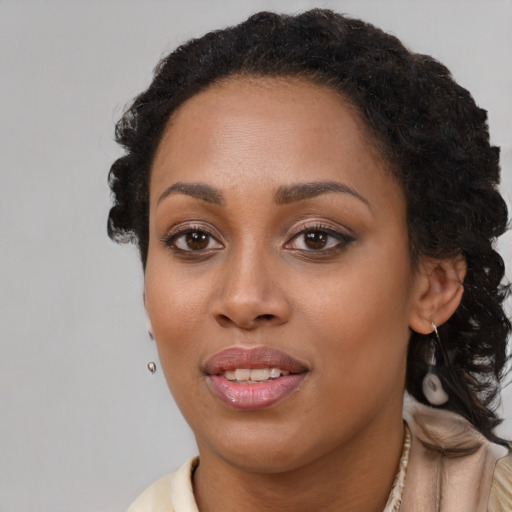 Joyful black young-adult female with long  brown hair and brown eyes
