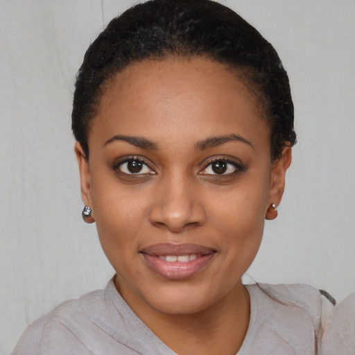 Joyful black young-adult female with short  black hair and brown eyes