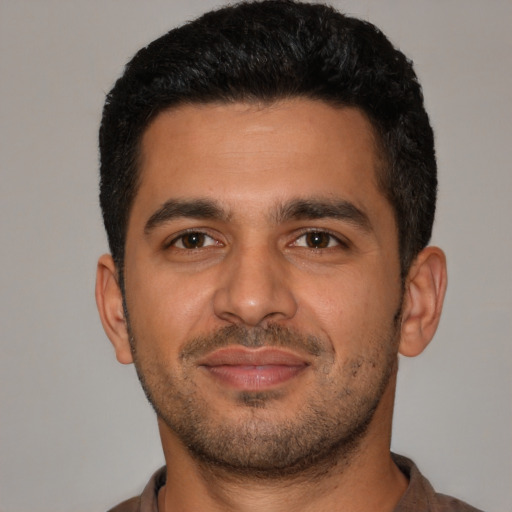 Joyful latino young-adult male with short  black hair and brown eyes