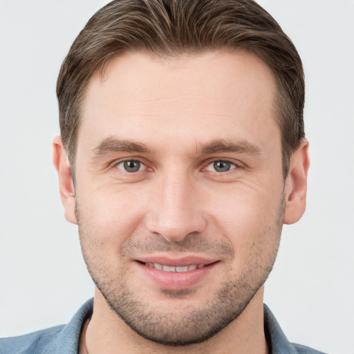 Joyful white young-adult male with short  brown hair and grey eyes