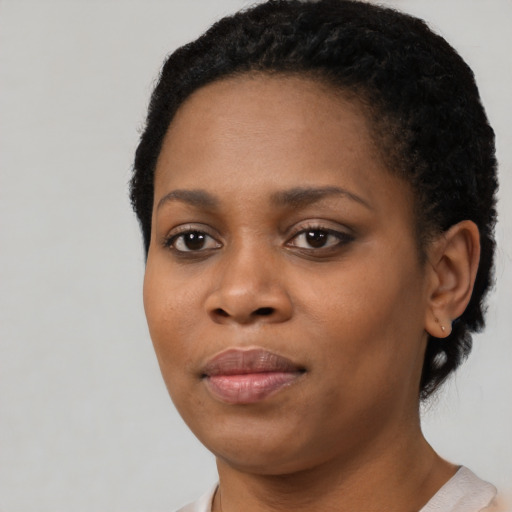 Joyful black young-adult female with short  black hair and brown eyes